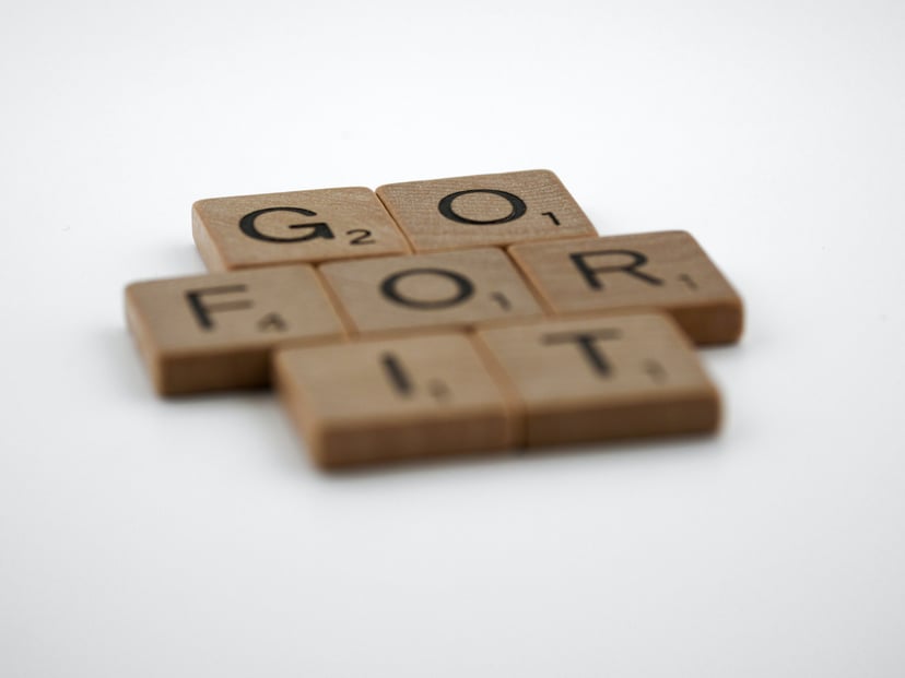wooden Scrabble tiles spelling out 'go for it'