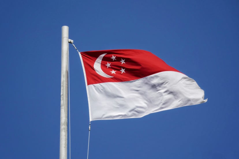 The flag of Singapore flying against a blue sky