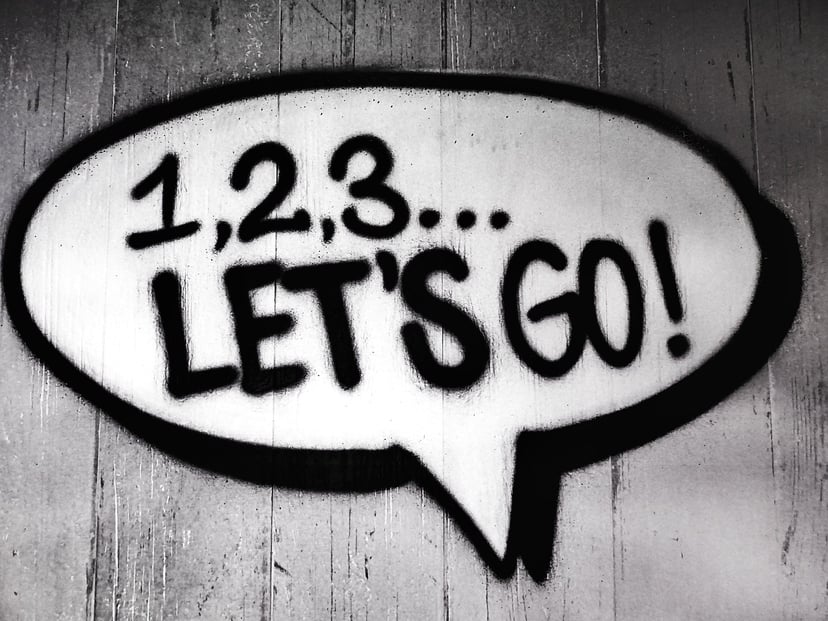 a spray painted speech bubble with '1, 2, 3 let's go' in it