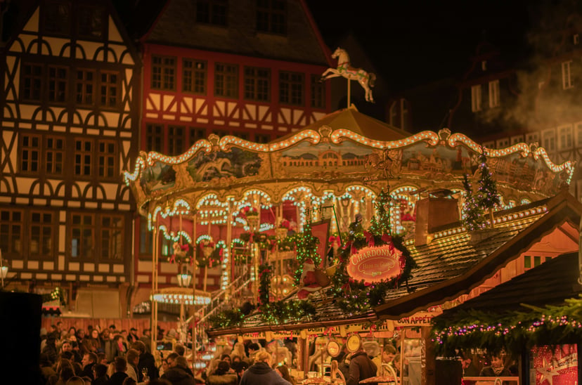 A carousel and old buildings in a European Christmas market