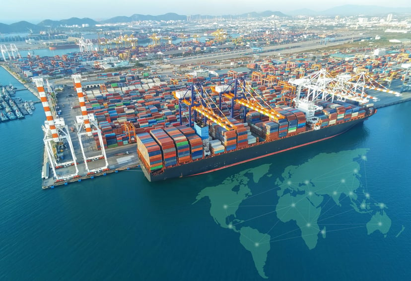 a container ship in a port with an image of a map of the world and connecting line on the water next to its 