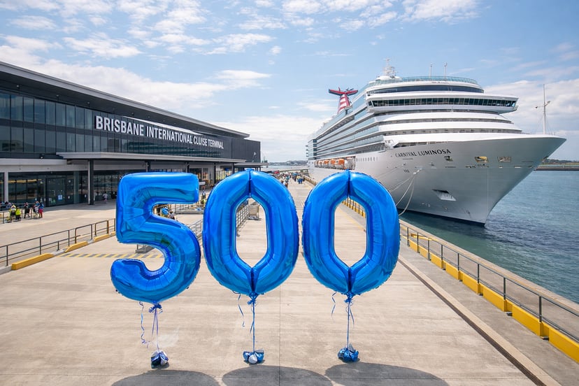 A ship docked at Brisbane International Cruise Terminal with balloons spelling '500' on the dock