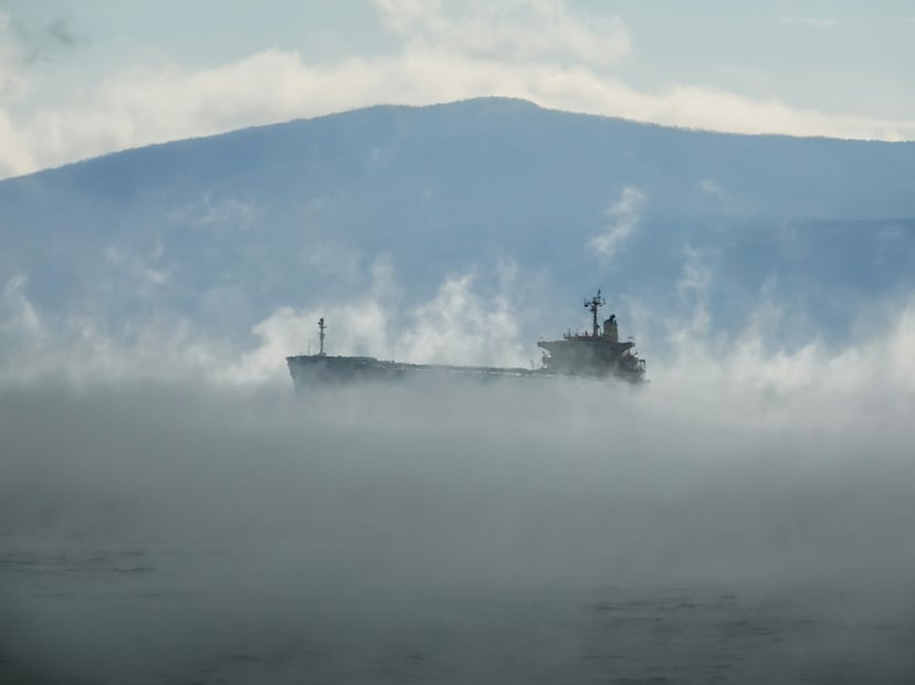 A tanker shrouded in mist as seen from a nearby ship's bridge