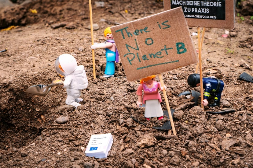 Lego figures holding a sign that says 'there is no planet B' 