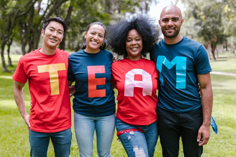 Four people wearing t-shirts that spell out the word 'team'