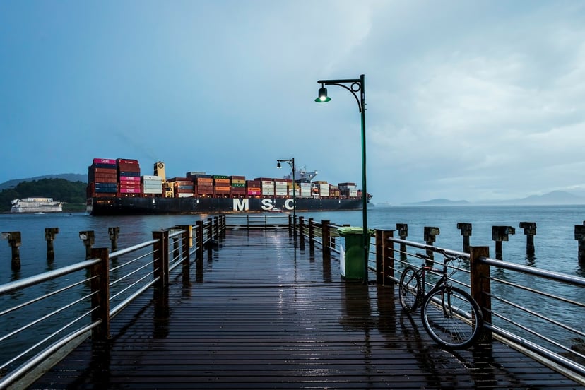 An MSC container ship as seen from a wooden pier