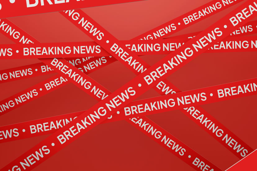 Criss crossing red tape with the words 'breaking news' on it