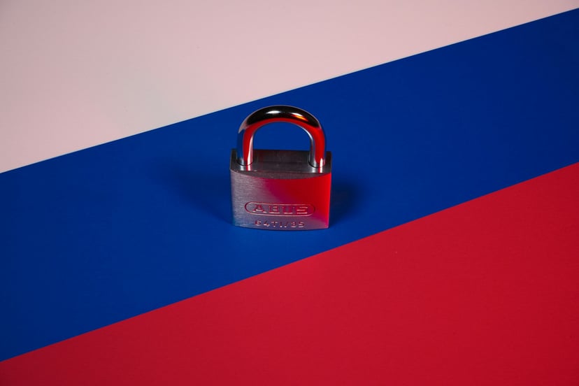 A locked padlock sitting on a Russian flag