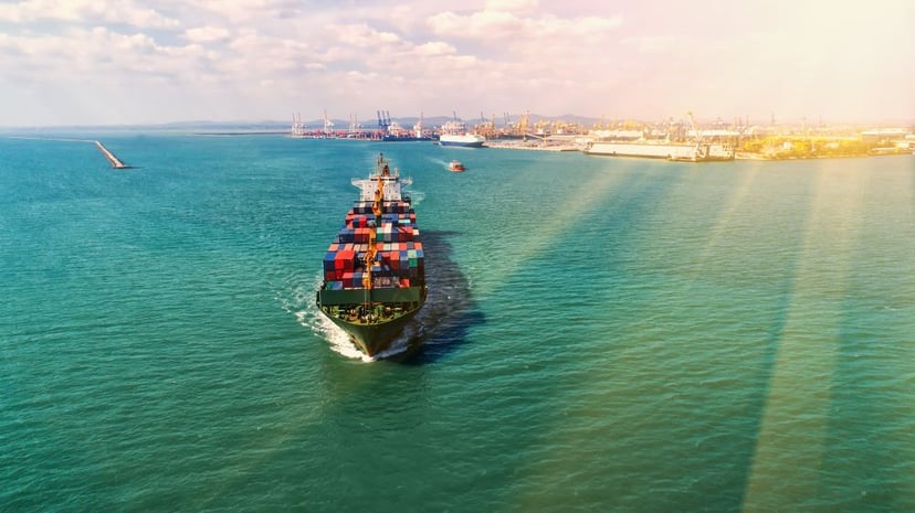 Sun rays shining over a container ship at sea