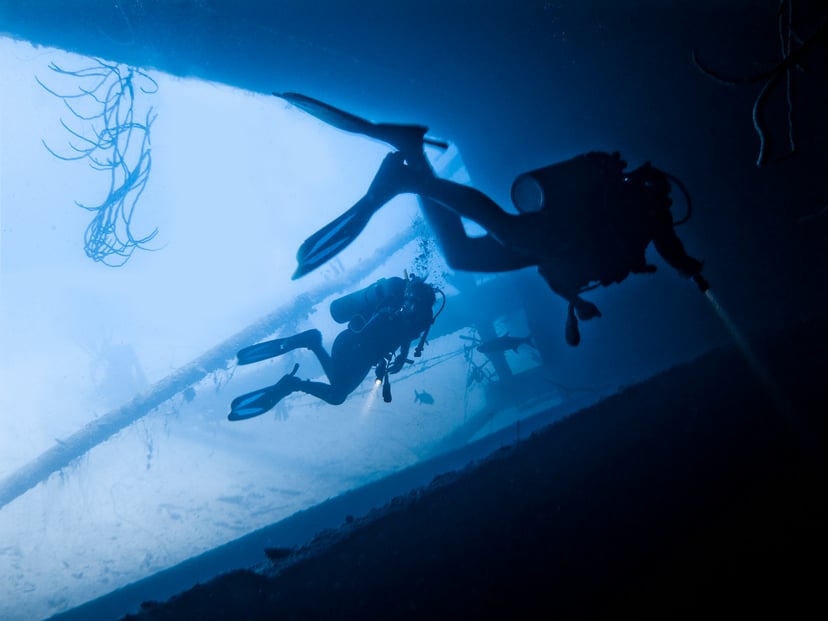 Two divers inspecting an underwater wreck 