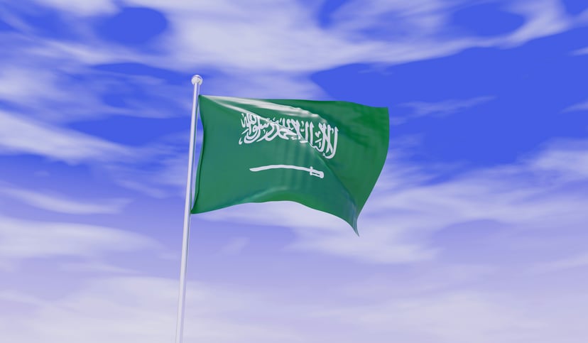 The flag of Saudi Arabia flying against a blue sky