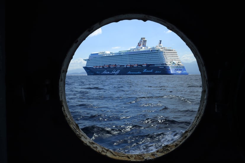 A Mein Schiff cruise ship seen from the porthole of another vessel