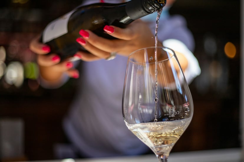 A bartender pouring a glass of wine