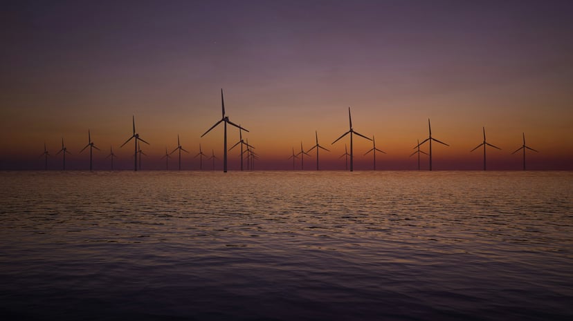 An offshore windfarm at sunset
