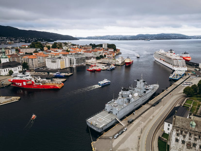 The harbor in Bergen, Norway showing small craft, a cruise ship and a naval ship