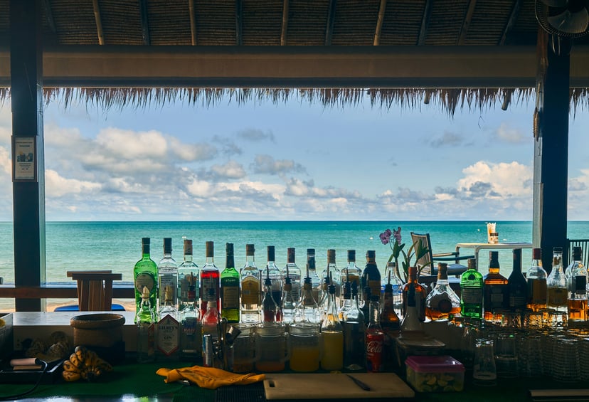 View from behind the bar at a beach bar looking out towards the ocean