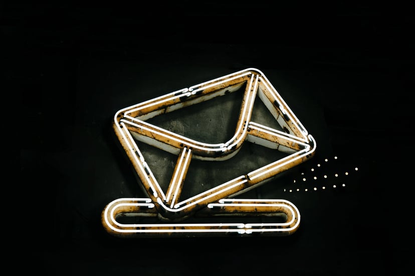 A neon sign depicting an envelope going into a slot