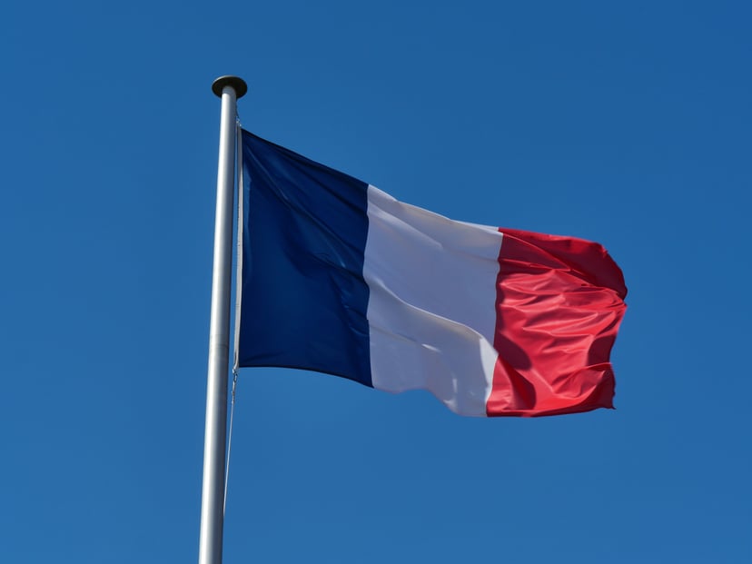 The French flag flying against a blue sky