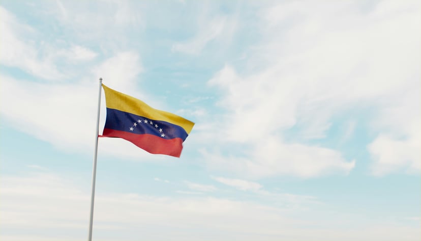 The flag of Venezuela flying against a blue sky