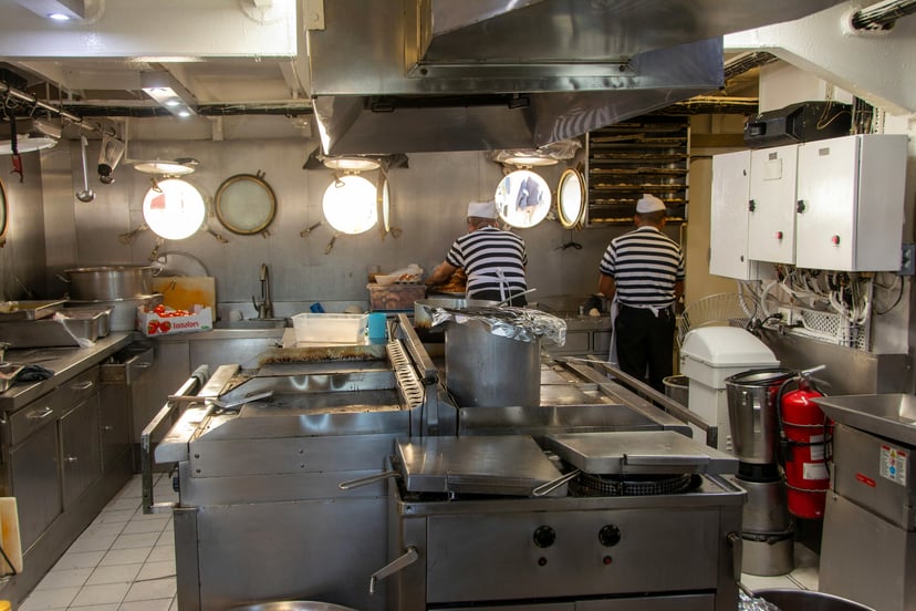 two ship's cooks working in the galley on a vessel