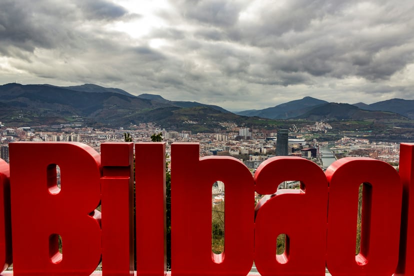 Large red letters spelling out Bilbao with the city in the background