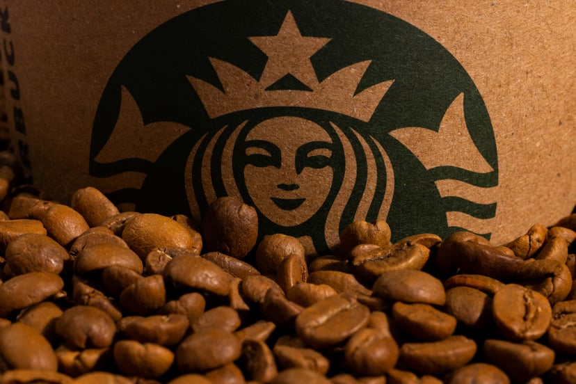 The Starbucks mermaid logo rising out of some coffee beans