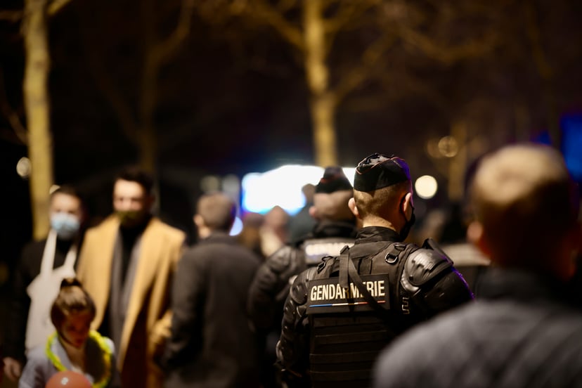 Two members of the Gendarmerie in a crowd of people at night
