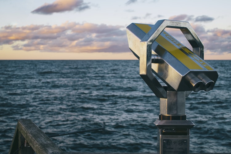 A telescope pointing at the ocean
