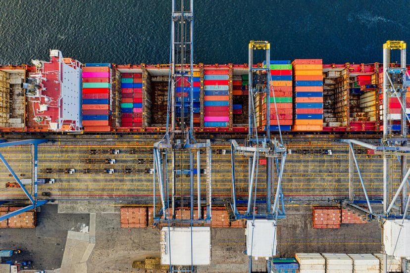 An aerial view of a cargo ship in port showing its cargo holds