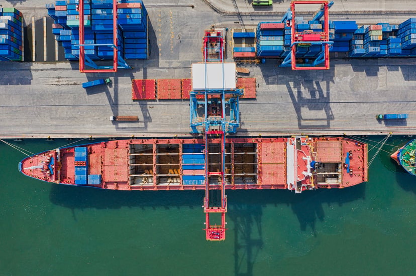 An aerial view of a cargo ship in port showing its cargo holds