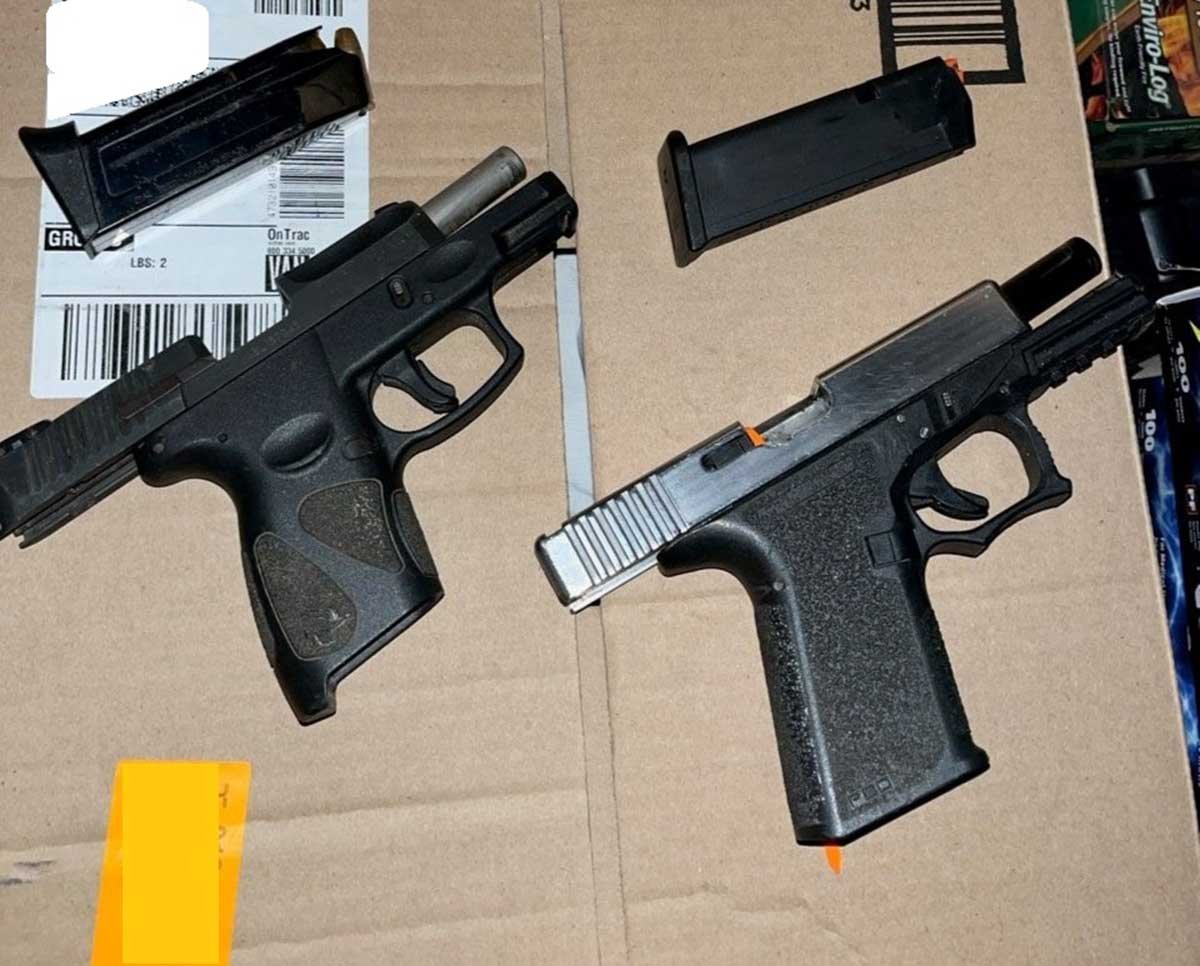 Two semiautomatic handguns displayed on a cardboard box