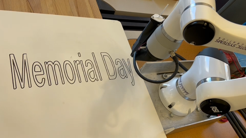 机器人手臂在纸张上写下 Memorial Day