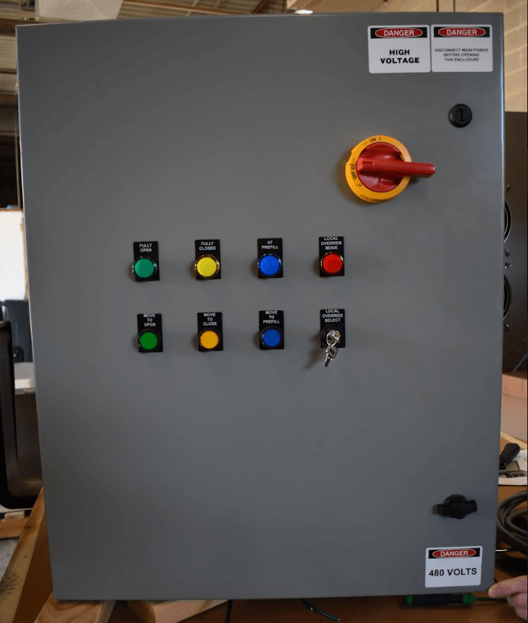 Gray electrical control cabinet with indicator buttons, key switch, and red disconnect handle for a proportional valve system