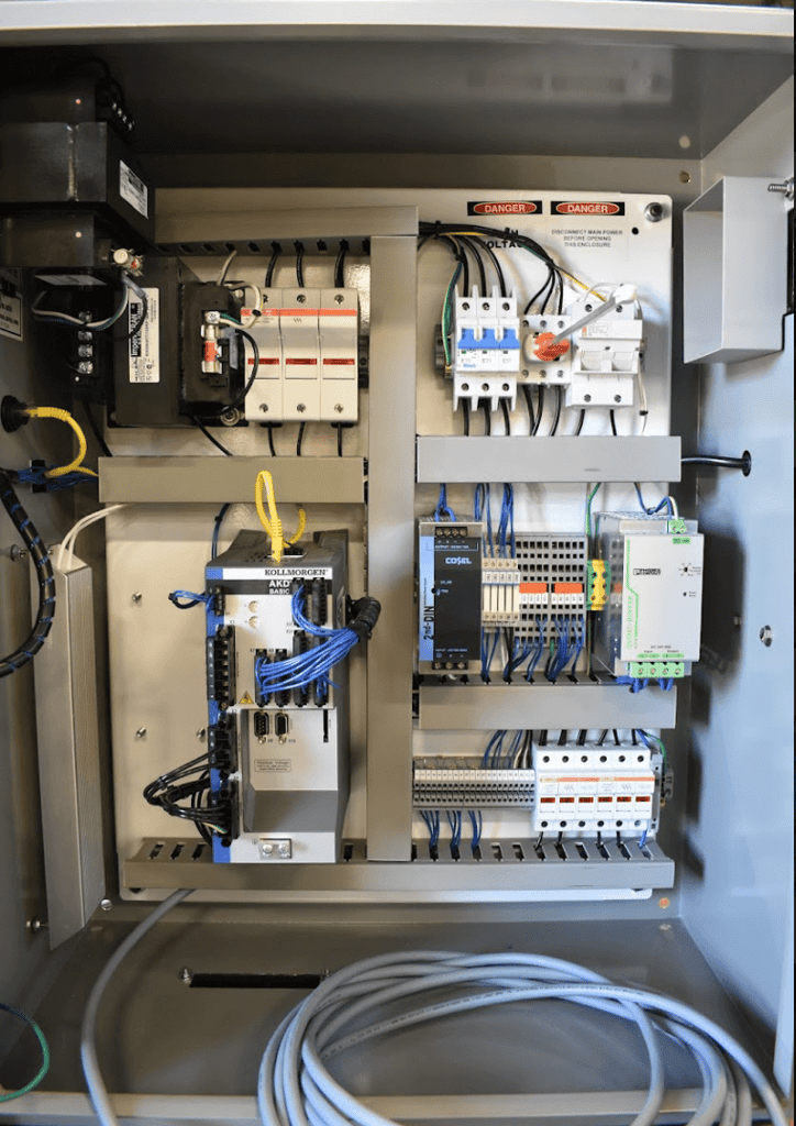 Open control cabinet with breakers, PLC modules, wiring, and drive components for valve control