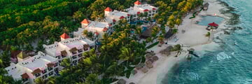Aerial view of resort with beach, tropical gardens and ocean