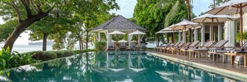 Pool at Cape Kudu Hotel with deck chairs next to it 