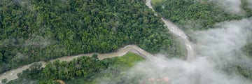 The Pacuare River winding through emerald jungle, veiled in morning mist 