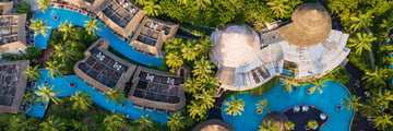 Birdseye view of a resort with pools and greenery