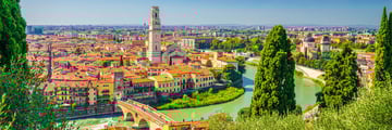 View of Verona's skyline with trees and a river in the foreground