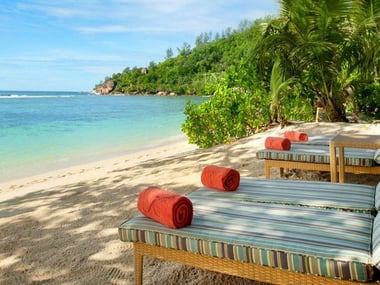 Beachfront loungers at Kempinski Seychelles Resort