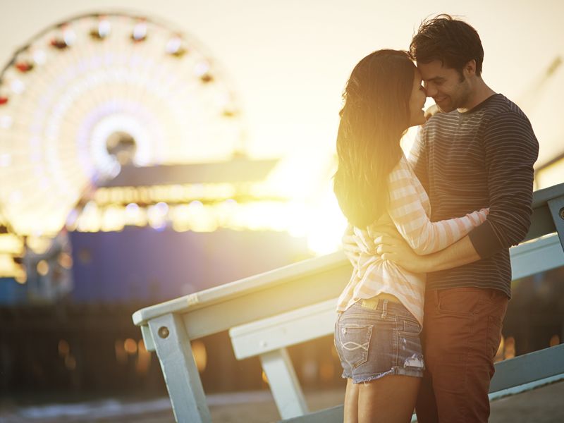 Couple by Santa Monica ferris wheel at sunset