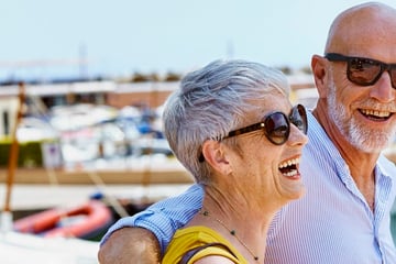 Couple walking along the harbour in Spain