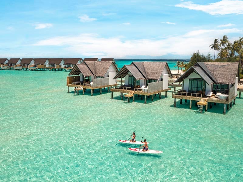 couple paddle boarding at Fushifaru Maldives