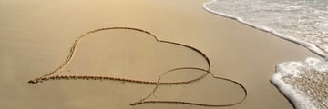 Hearts drawn in the sand on a beach in the Grenadines