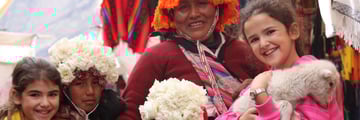 Family with Peruvian locals at Pisac Market. Copyright: Intrepid
