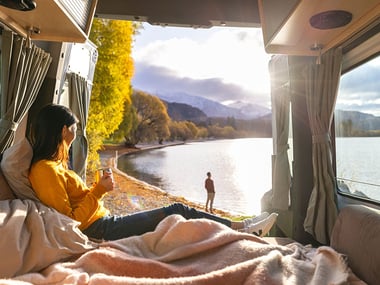 girl sitting in maui Ultima motorhome, looking out onto a lake