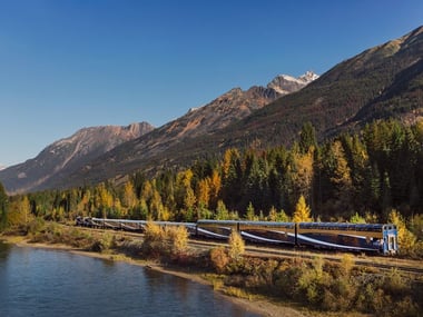 Rocky Mountaineer travelling along the water's edge on Journey Through the Clouds
