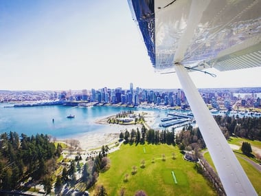 Seaplane flying over Stanley Park as it makes its descent to Coal Harbour