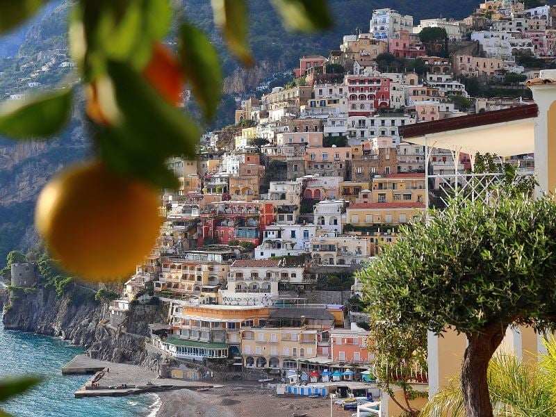 close up of lemon with hills and buildings in sorrento behind
