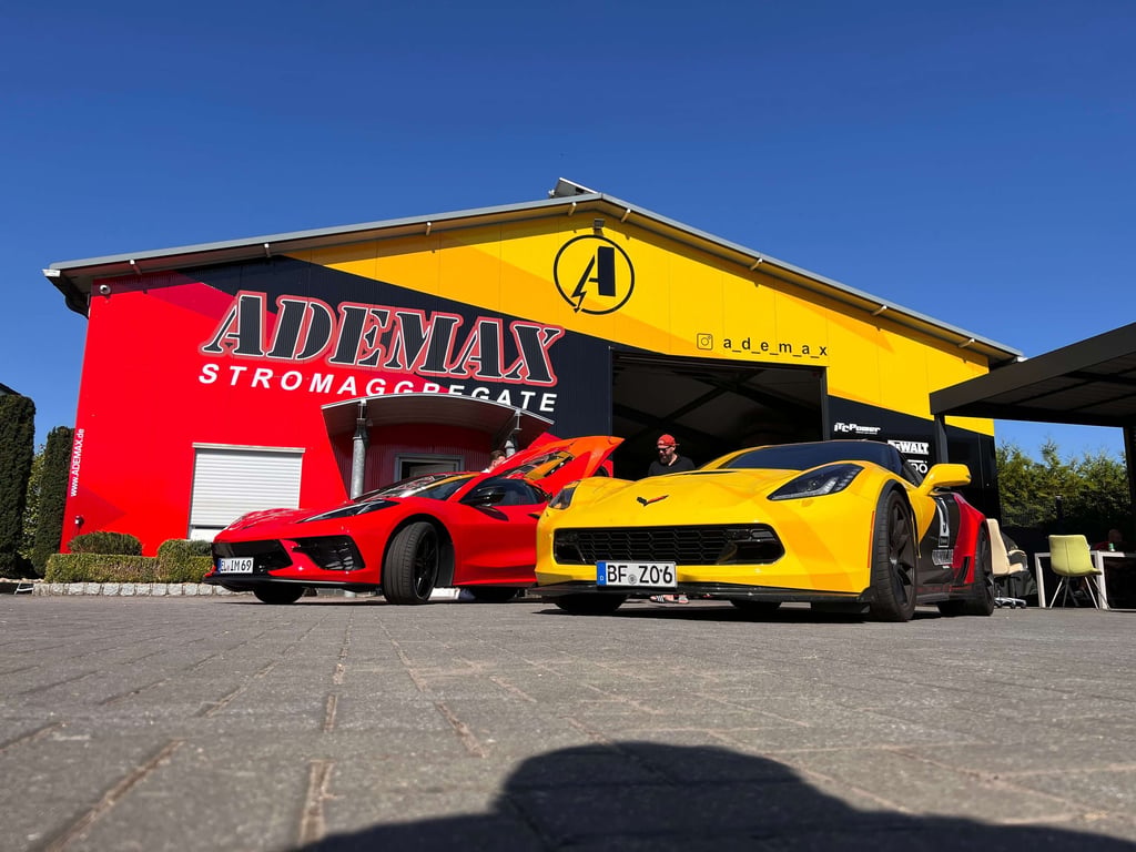 ADEMAX Showroom mit foliertem rotem und gelbem Corvette davor